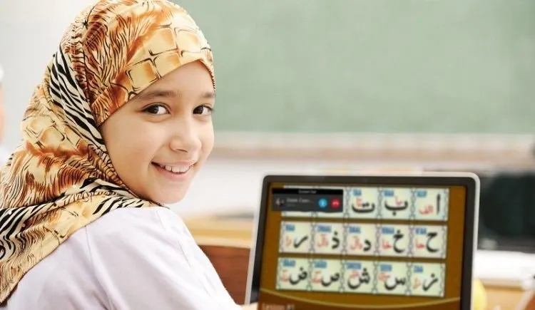 Child girl learning Noorani Qaida online on laptop with interactive Quran lessons in USA and UK